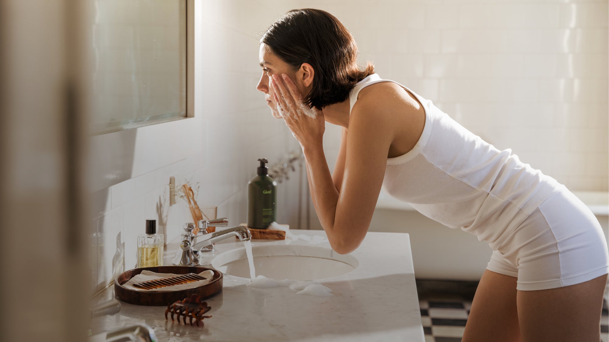 Woman washing her face with Gntl Skin Wash a facial-grade wash for everywhere there's skin.